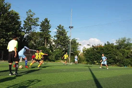 Một pha tranh chấp bóng trong lượt đi Đội A – Đội B